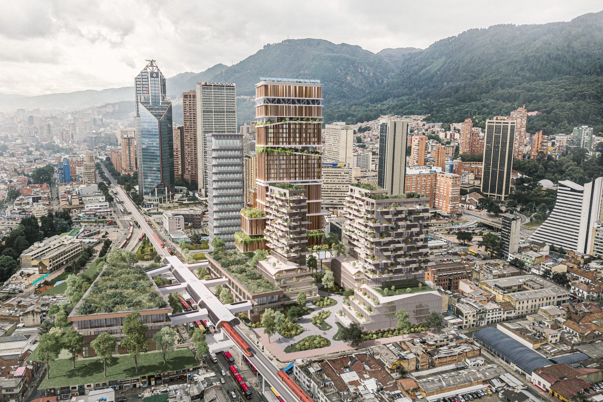 Vista aérea urbana con edificios altos, complejo con terrazas verdes, vía elevada con buses rojos y 