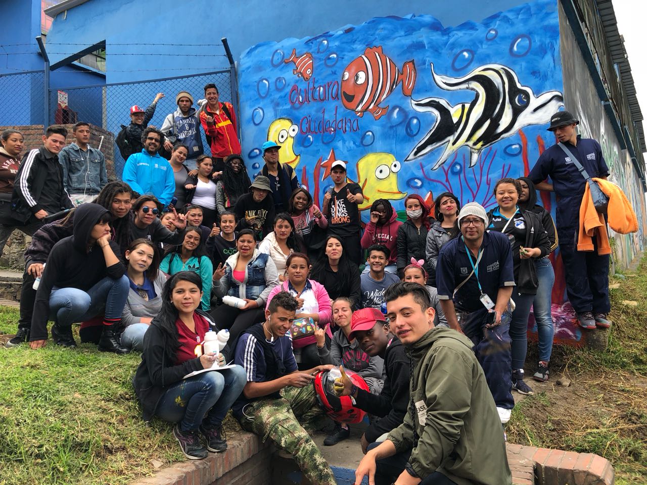 Participantes de la campaña junto a un mural pintado