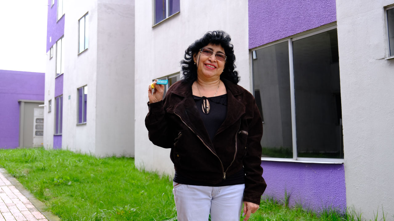 Mujer sosteniendo llavero "Bogotá el Mejor Hogar"